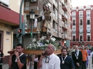 Un grupo de cofrades lleva a hombros a la Virgen del Carmen en el Grao