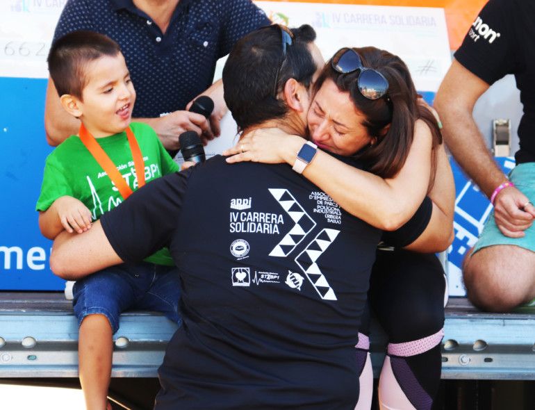 La gerente de APPI, Romina Moya, abraza al padre de Álex, el pequeño de 4 años afectado con el síndrome STXBP1, tras la entrega de medallas a los niños de esta asociación.