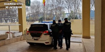 Dos agentes de la Guardia Civil conducen al detenido en Polinyà de Xúquer
