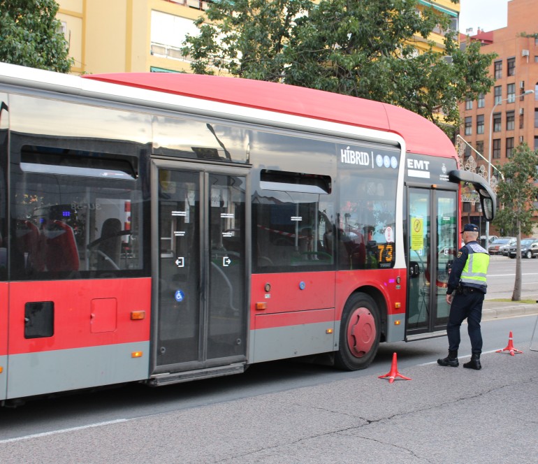 Agente junto a un autobús de la EMT Valencia