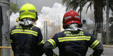 Dos bomberos del ayuntamiento de Alicante contemplan una mascletà