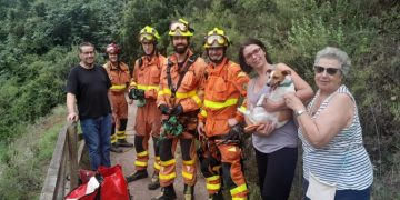 Los bomberos posan junto a la mujer y su perro, todo ha acabado bien.