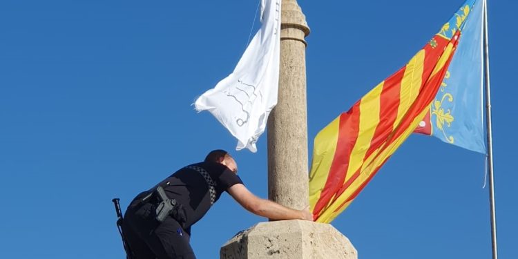 Un policía local retira una bandera con versos del Corán de las Torres de Serranos