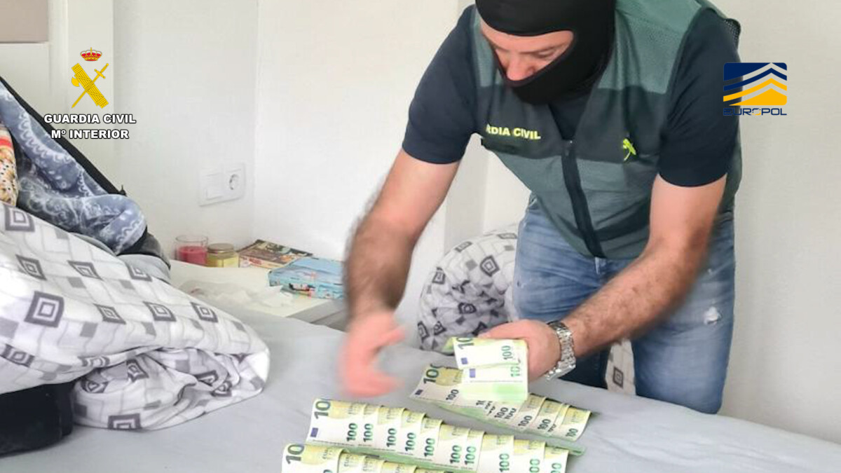 Un agente inspecciona billetes de 100 euros intervenidos en uno de los registros