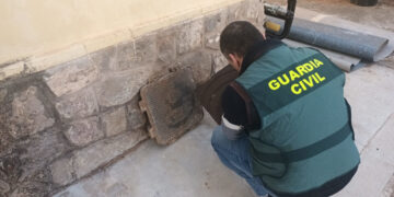 Un agente inspecciona dos tapas de arqueta hurtadas por el detenido