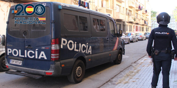 Agente de la Policía Nacional junto a un furgón policial en las Casitas Rosas