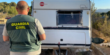 Un agente de la Guardia Civil inspecciona una caravana