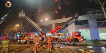 Los bomberos trabajando en la extinción del incendio del edificio de Campanar