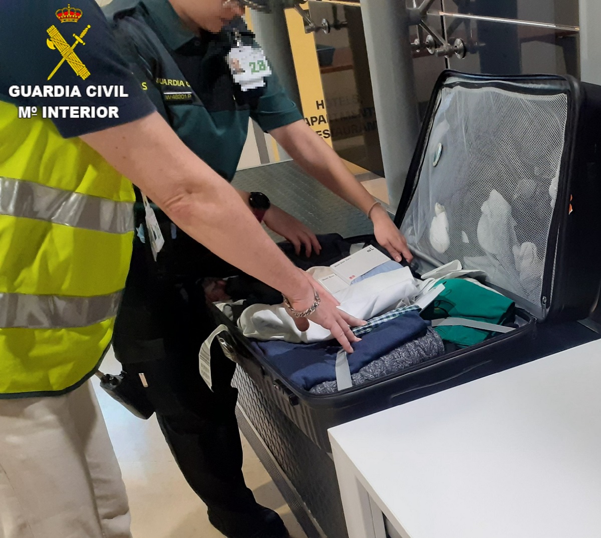 Agentes de la Guardia Civil revisa una maleta en el Aeropuerto de Valencia