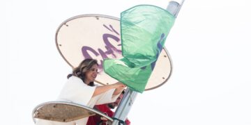 La alcaldesa de Valencia, María José Catalá, coloca la bandera verde en una de las playas del Sur