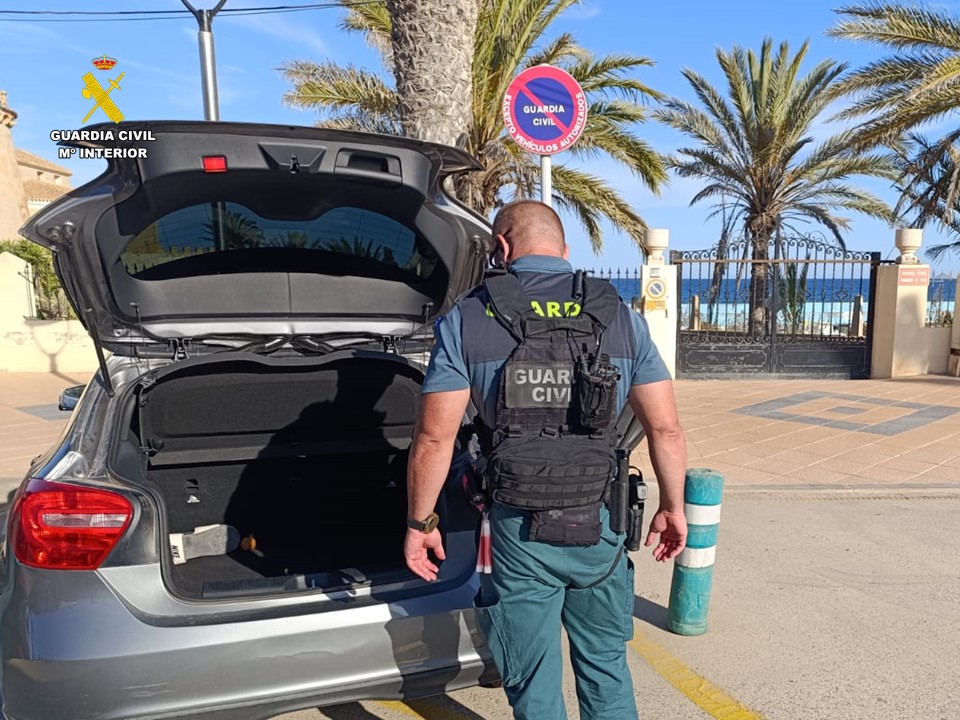 Un agente inspeccionando el maletero de un coche