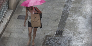 Una mujer camina bajo la lluvia. EFE/Manuel Bruque/Archivo