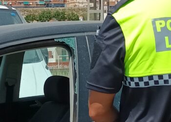 Un agente de la Policía Local de Elda junto al cristal roto del coche para rescatar al bebé de su interior