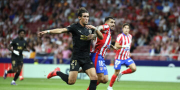 El delantero argentino del Atlético de Madrid Ángel Correa (d) lucha con Jesús Vázquez, del Valencia, durante el partido de la quinta jornada de LaLiga EA Sports entre el Atlético de Madrid y el Valencia CF, este domingo en el Cívitas Metropolitano de la capital española. EFE/Ballesteros