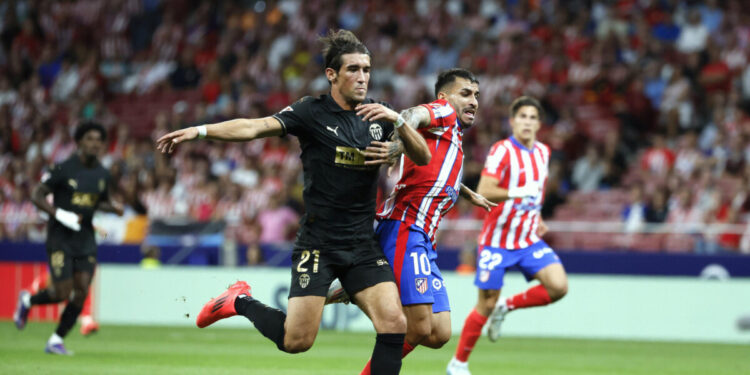 El delantero argentino del Atlético de Madrid Ángel Correa (d) lucha con Jesús Vázquez, del Valencia, durante el partido de la quinta jornada de LaLiga EA Sports entre el Atlético de Madrid y el Valencia CF, este domingo en el Cívitas Metropolitano de la capital española. EFE/Ballesteros