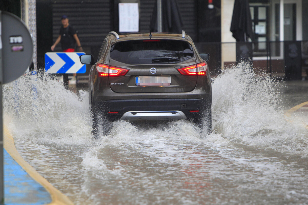 Una vehículo circula por una calzada anegada por el agua caida por la lluvia este martes en Santa Pola cuando la mayor parte del territorio de la Comunitat podría recibir este martes chubascos tormentosos localmente fuertes y acompañados de granizo. EFE/Morell