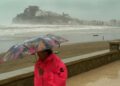 Una mujer se protege en el paseo marítimo de Peñiscola (Castellón). Archivo/EFE / DOMENECH CASTELLO.